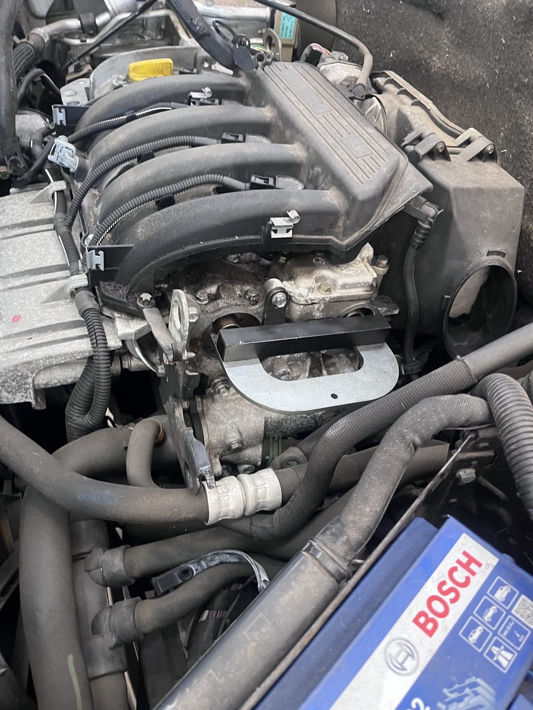 Motorruimte van een Renault met vergrendelgereedschap en een Bosch accu